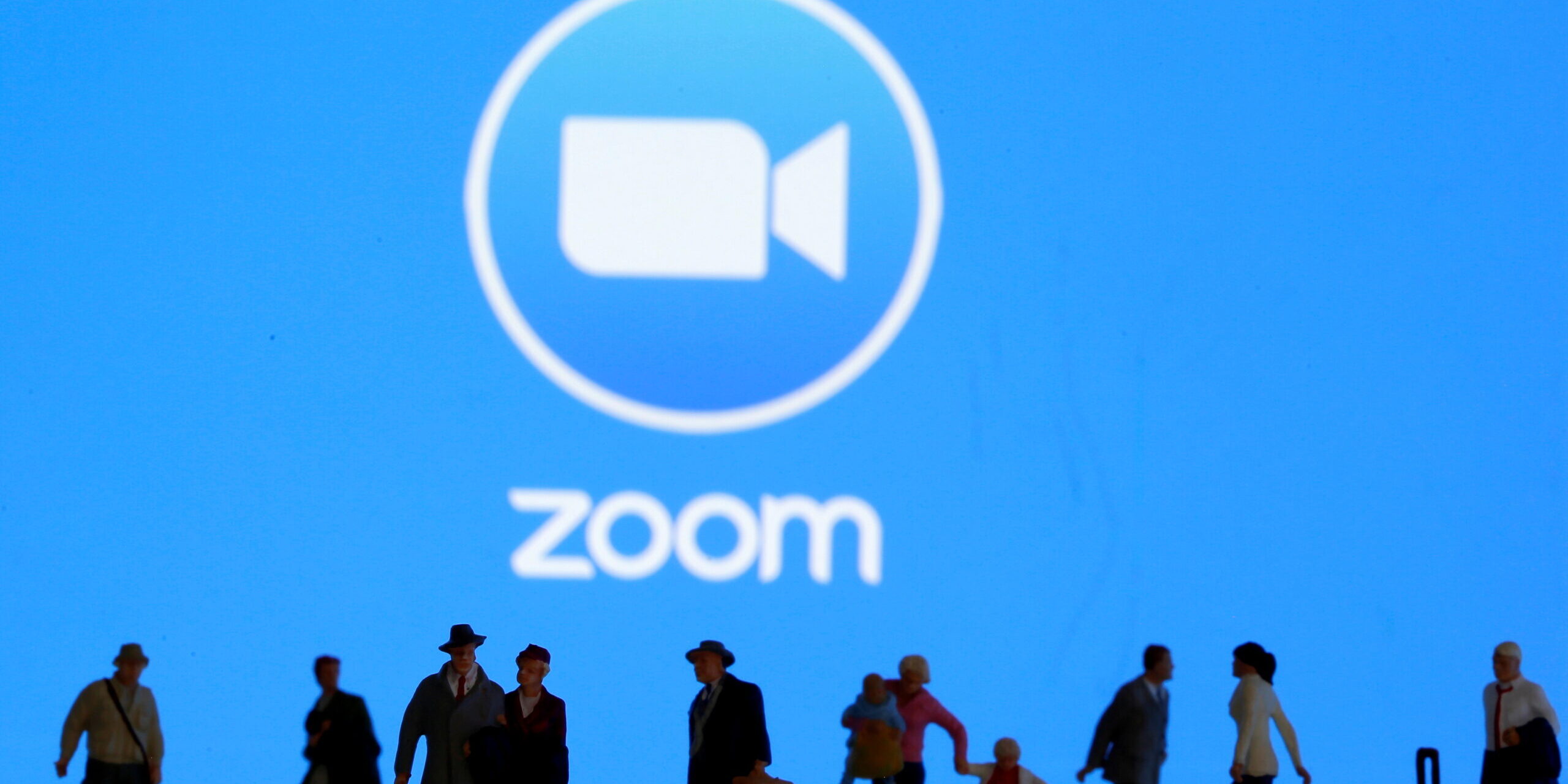 FILE PHOTO: Small toy figures are seen in front of diplayed Zoom logo